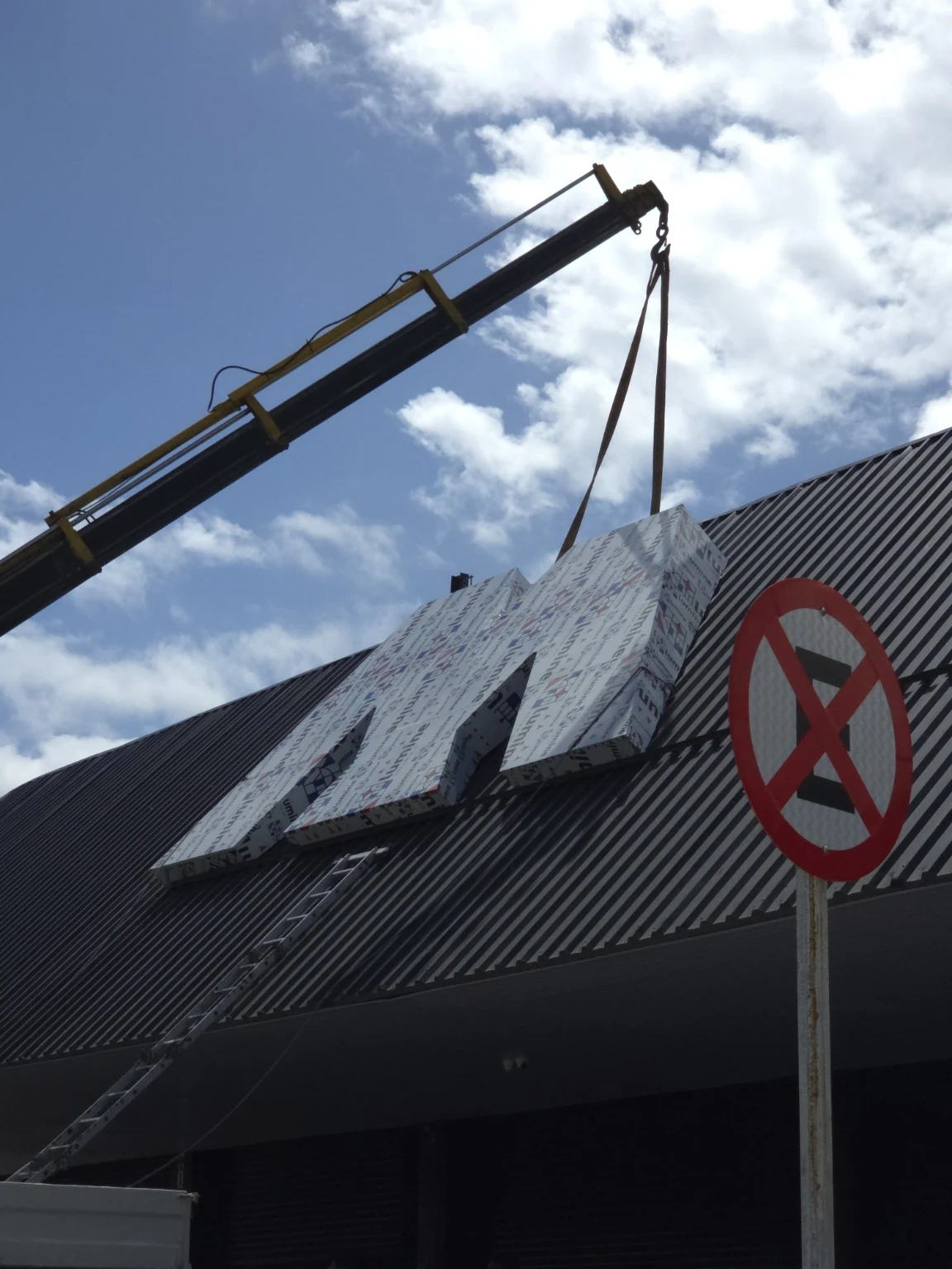 Munck içando uma letra caixa para montagem na fachada