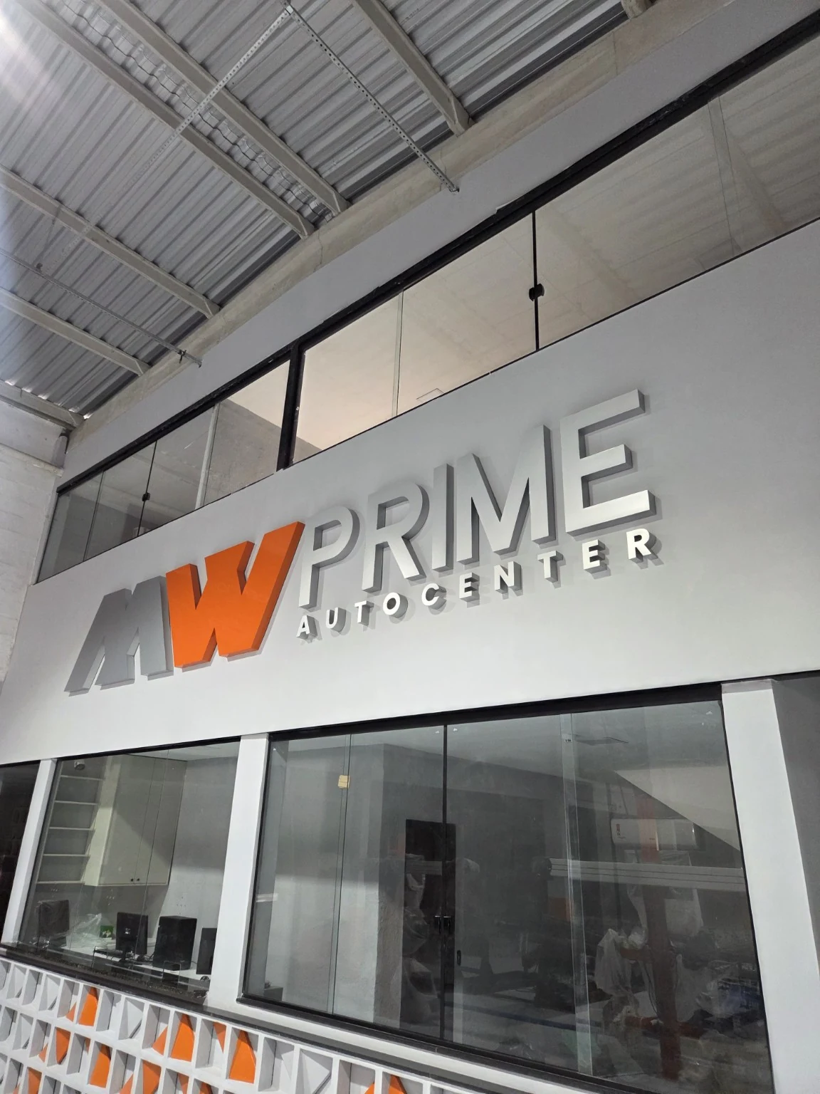 Letreiro tridimensional cinza e laranja da MW Prime Autocenter