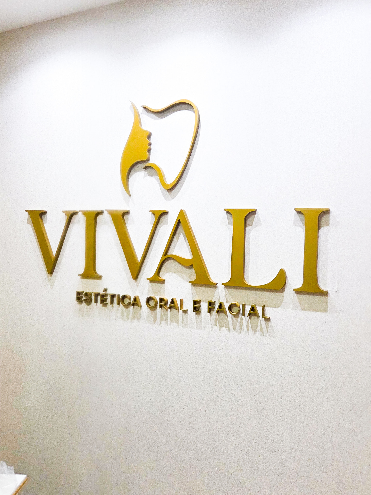 Letreiro dourado em relevo instalado em parede interna